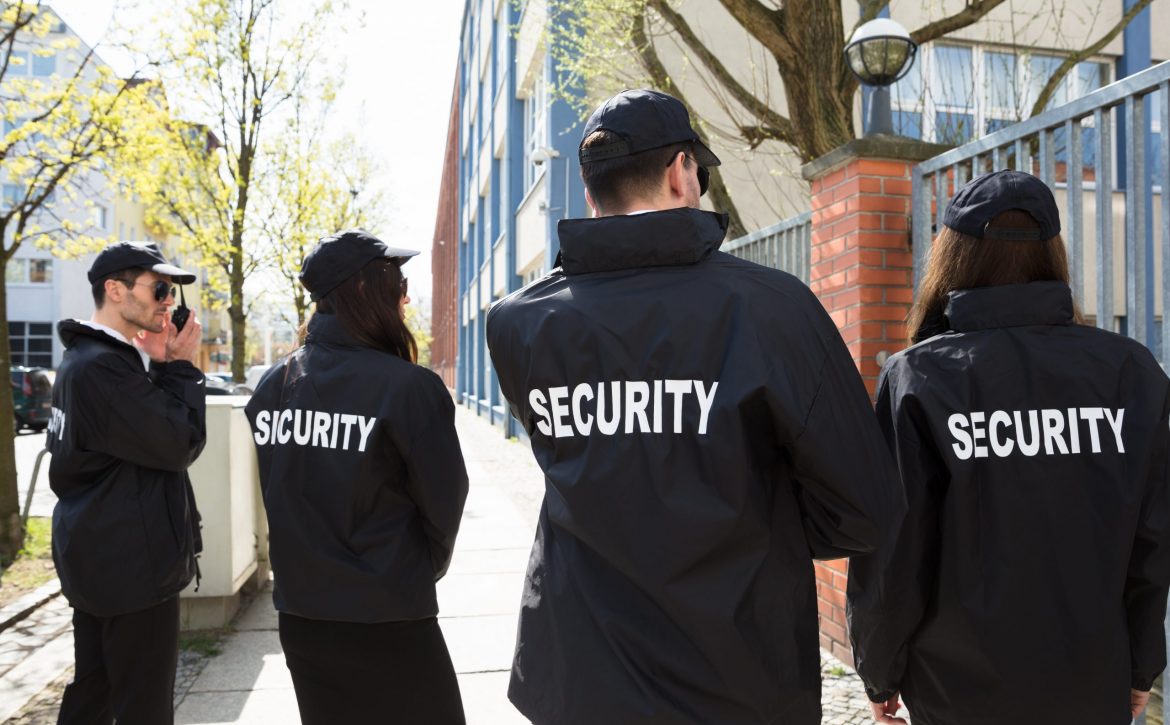 Rear,View,Of,Security,Guards,In,Black,Uniform,Standing,Outside